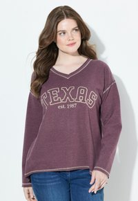 Pullover a maniche lunghe color marsala con scollatura a V, che presenta la scritta "TEXAS" e "est. 1987" in testo crema. Orlo grezzo e dettagli di cucitura in contrasto.