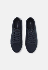Tmavě modré plátěné tenisky s nízkým střihem, se šněrováním, bílými detaily a logem na stélce. Hladká textura.