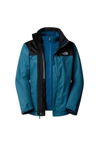 Veste d'extérieur superposée bleu et noir avec fermeture éclair à l'avant et col haut, arborant le logo The North Face sur la poitrine.