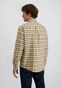 Langarm shirt in geel en bruin geruit, met een standaard kraag, knoopmanchetten en een afgeronde zoom met een achterste yoke detail.