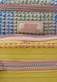 Ritszak met een veelkleurige geweven stof, voorzien van roze en gele accenten, zilveren hardware en een logo-label.