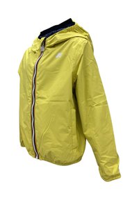 Giacca impermeabile gialla con cappuccio, zip frontale, polsini elasticizzati e tasche laterali. Presenta il logo sul lato sinistro superiore.