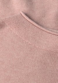 Tessuto lavorato a maglia di colore rosa chiaro con un motivo strutturato a coste. Presenta un collo rotondo e liscio e un aspetto morbido e accogliente.