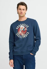 Tamno plavi dukserica od pamuka s okruglim izrezom i dugim rukavima. Grafički tekst "Prepreke su izazovi" s ilustracijom biciklista.