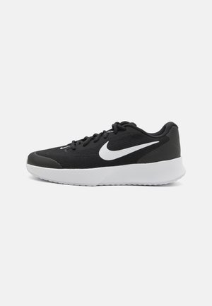 Czarne buty sportowe z siateczkową cholewką, białym logo w kształcie łyżwy, wyściełanym kołnierzem i teksturowaną białą podeszwą średnią. Charakteryzują się lekką konstrukcją i sznurowadłami.