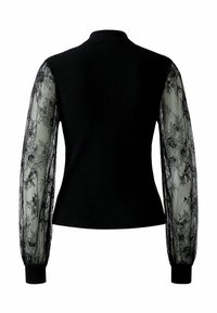 Pull en maille noire avec des manches en dentelle transparente à motifs floraux, col montant ajusté et détails de poignets noirs.