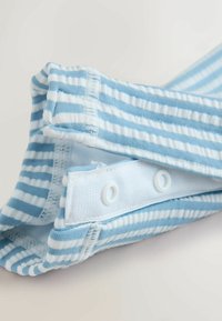 Tela de rayas azul claro con líneas horizontales blancas, con dos cierres de presión. Textura suave, con diseño de cinturilla elástica.