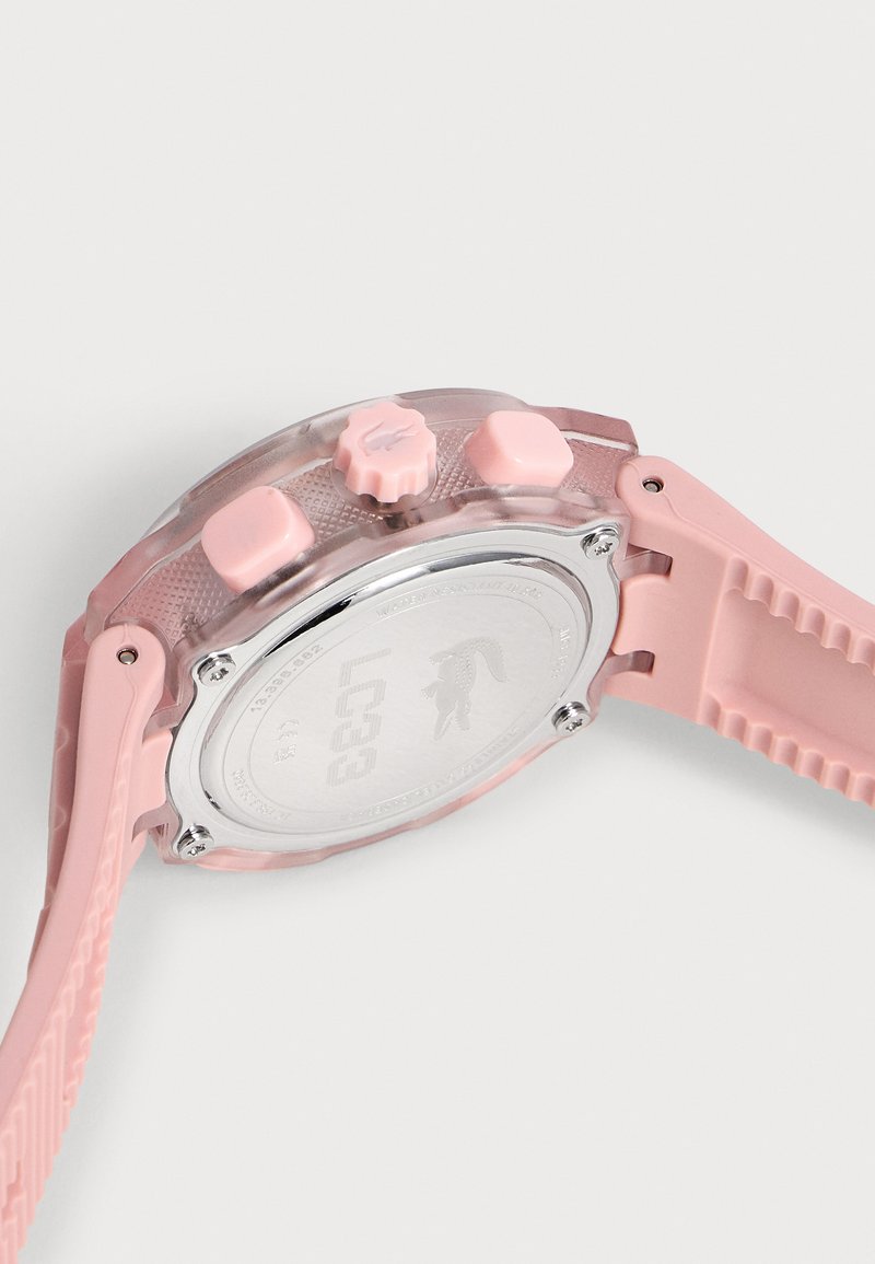 Rückseite einer durchscheinend rosa Armbanduhr mit einem strukturierten rosa Armband, drei seitlichen Tasten und einem silbernen Metallgehäuseboden.