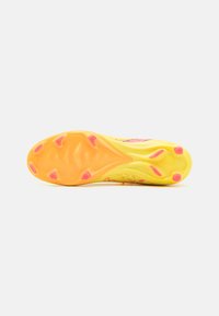 Sola di scarpa atletica gialla con una suola in gomma testurizzata. Presenta borchie rosa e un design a motivi per la trazione. Leggera e flessibile.