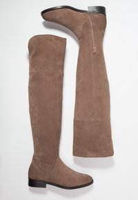 Brązowe zamszowe kozaki za kolano na płaskiej podeszwie, z bocznym zamkiem i bezszwowym designem. Gładka tekstura i zaokrąglony nos.