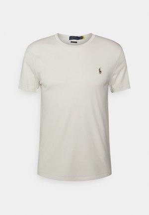 Polo blanco liso de manga corta y cuello redondo con un pequeño logo bordado de un jugador de polo a caballo en el pecho izquierdo.