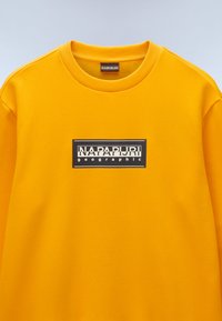 Geel sweatshirt met een ronde hals, met een zwart rechthoekig logo met witte tekst gecentreerd op de borst. Glad textuur.