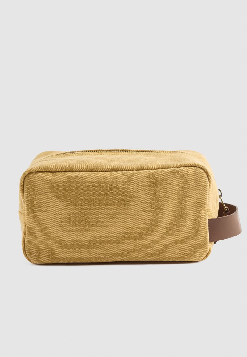 Borsa cosmetica gialla in tela con forma rettangolare, chiusura a zip e manico in pelle marrone. Tessuto testurizzato con bordi puliti.