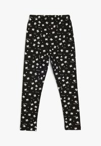 Leggings negros con una cinturilla elástica que presenta un patrón repetido de gatos blancos y elementos de texto en varias formas. Tela suave y elástica.