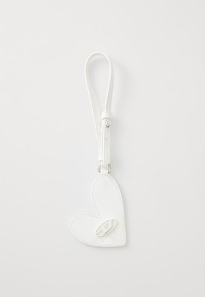Porte-clés en cuir blanc en forme de cœur, avec une texture lisse, doté d'une sangle et d'une petite attache en boucle.