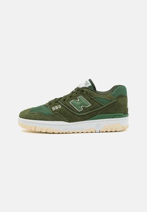 Zielony sneaker New Balance 550 z panelami zamszowymi i siateczkowymi, białą środkową podeszwą, beżową zewnętrzną podeszwą oraz "550" nadrukowanym w pobliżu sznurowadeł, prezentowany na białym tle.