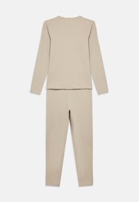 Σετ με μπεζ βαμβακερό τοπ μακρυμάνικο και εφαρμοστά παντελόνια. Απλός σχεδιασμός με στρογγυλή λαιμόκοψη και απαλή υφή, κατάλληλο για ρουχισμό χαλάρωσης ή ύπνου.