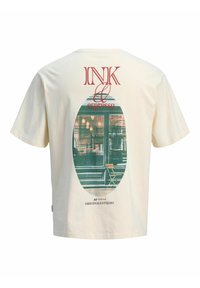 T-shirt color crema con grafica di una finestra vintage di un caffè e una sedia, con il testo "INK & espresso" e "ORIGINALS STUDIO" sul retro.