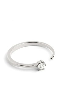 Anillo abierto de plata con una banda lisa que presenta un solo cristal redondo claro engastado en un ajuste de garras. Acabado pulido, diseño elegante.