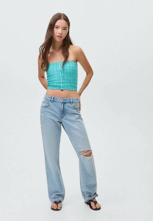 Tyrkysový nabíraný crop top, světle modré roztrhnuté rovné džíny a černé žabky. Hladká textura, pohodlný střih a jemné detaily.