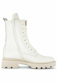Botte de combat en cuir blanc avec fermeture éclair latérale, lacets à l'avant, languette de traction et semelle en caoutchouc beige épaisse.