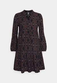 Svart långärmad klänning med diamant- och geometriska mönster i rött och vitt, med ett nyckelhålsknäppning och utsvängd kjol.