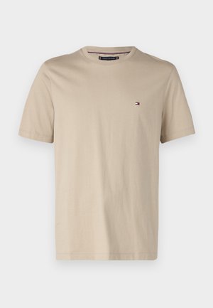 T-shirt beige a maniche corte in cotone con scollatura rotonda, dotato di un piccolo logo sul lato sinistro del petto. Tessuto liscio, design casual.