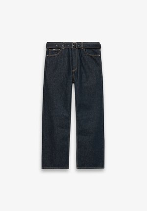 Tumši zili taisnas piegriezuma džinsa bikses ar jostas cilpām un melnu jostu, priekšējām kabatām un redzamām šuvēm uz balta fona.