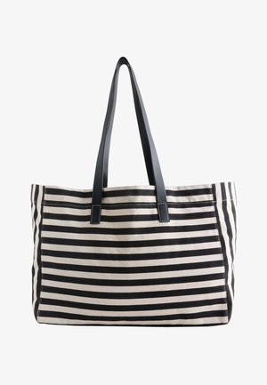 Sac fourre-tout à rayures horizontales noires et blanches avec deux longues anses noires, forme rectangulaire et texture en tissu.