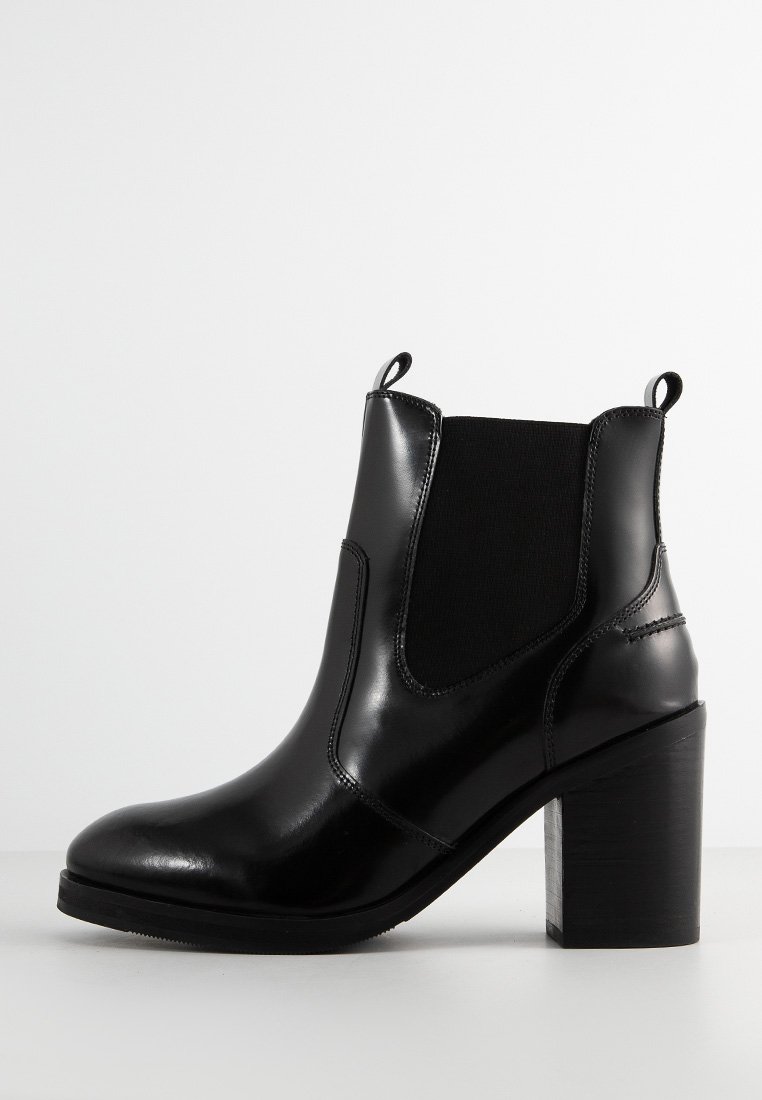 Schwarze Leder Stiefelette mit elastischen Seitenpaneelen, abgerundeter Zehe und blockartigem Absatz. Verfügt über eine glatte Textur und Nähte.
