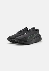 Zwarte sportieve schoenen met een textuurstof, groene accenten en een gevoerde zool. Voorzien van stevige veters en een gevoerde kraag voor ondersteuning.