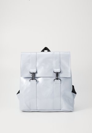 Mochila azul clara e brilhante, feita de material à prova d'água, apresentando duas correias pretas com fecho e um punho no topo. Textura suave com um logo minimalista.
