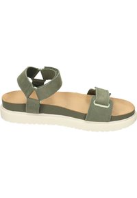 Sandale en suède vert avec une semelle blanche épaisse. Présente des brides croisées et une seule lanière ajustable. Semelle en cuir lisse et quincaillerie minimale.