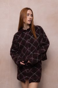 Suéter borroso color burdeos con cuello de solapa, que presenta un patrón de diamantes en blanco y gris claro, de corte holgado y mangas largas.