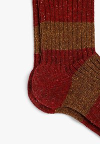 Calcetines de rayas rojas y marrones con una textura acanalada, que cuentan con una puntera y un talón reforzados para mayor durabilidad.