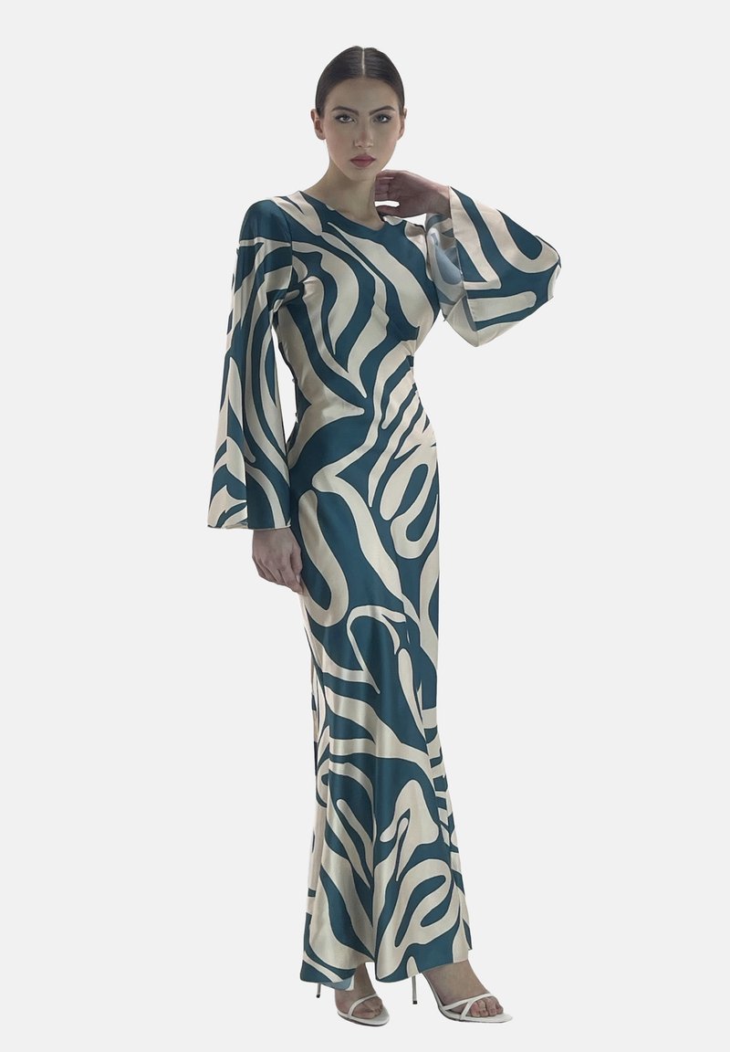 Långärmad klänning med ett abstract mönster i teal och krämfärg, gjord av ett mjukt tyg med en figursydd silhuett och utsvängda ärmar.