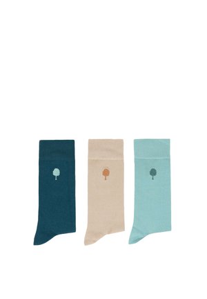 Trois paires de chaussettes unies en bleu sarcelle, beige et bleu clair, chacune avec une petite icône d'arbre près du haut du poignet.