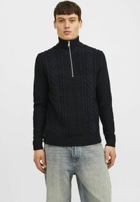 Marineblauer Strickpullover mit hohem Kragen und halbem Reißverschluss, ausgestattet mit einem strukturierten Zopfmuster sowie gerippten Bündchen und Saum.