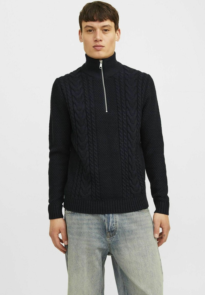 Marineblauer Strickpullover mit hohem Kragen und halbem Reißverschluss, ausgestattet mit einem strukturierten Zopfmuster sowie gerippten Bündchen und Saum.