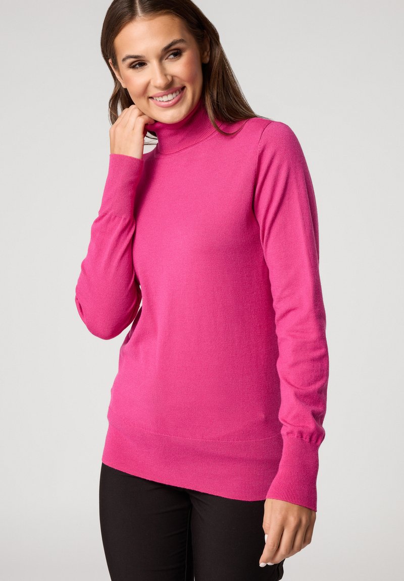 Dopasowany sweter typu golf w jasnoróżowym kolorze, wykonany z miękkiego materiału, z długimi rękawami oraz ściągaczami przy mankietach i u dołu.