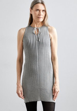 Graues, geripptes, ärmelloses Kleid mit einer Bindedetail am Hals. Es hat vertikale Streifen und einen geraden Saum, kombiniert mit schwarzen Leggings.