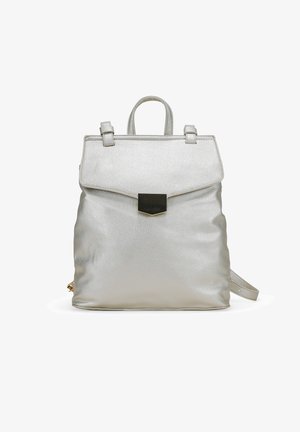 Mochila de cuero plateada con una textura suave, forma rectangular, asa superior y un cierre magnético en la parte frontal. Incluye una correa ajustable.