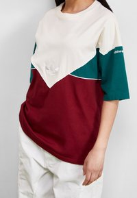 Färgat blockad, oversized t-shirt i krämfärgad, grön och vinröd bomull. Har broderad Adidas-logotyp och vit piping längs designens sömmar.