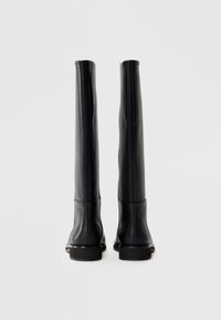 Tall black leather boots with a smooth finish, rounded toes, and a low block heel. The design features minimal stitching and no visible hardware.
