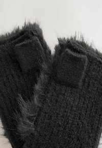 Mustad sõrmeotsadeta mustad kindad tekstureeritud kudumisega, pehme kunstkarusnahaga äärtega ja Velcro aktsentidega randmel reguleeritava sobivuse tagamiseks.