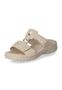 Beige schuifsandalen van zacht leer, met twee banden, waarvan één een decoratief horizontaal patroon heeft en een grote metalen ring als accent.