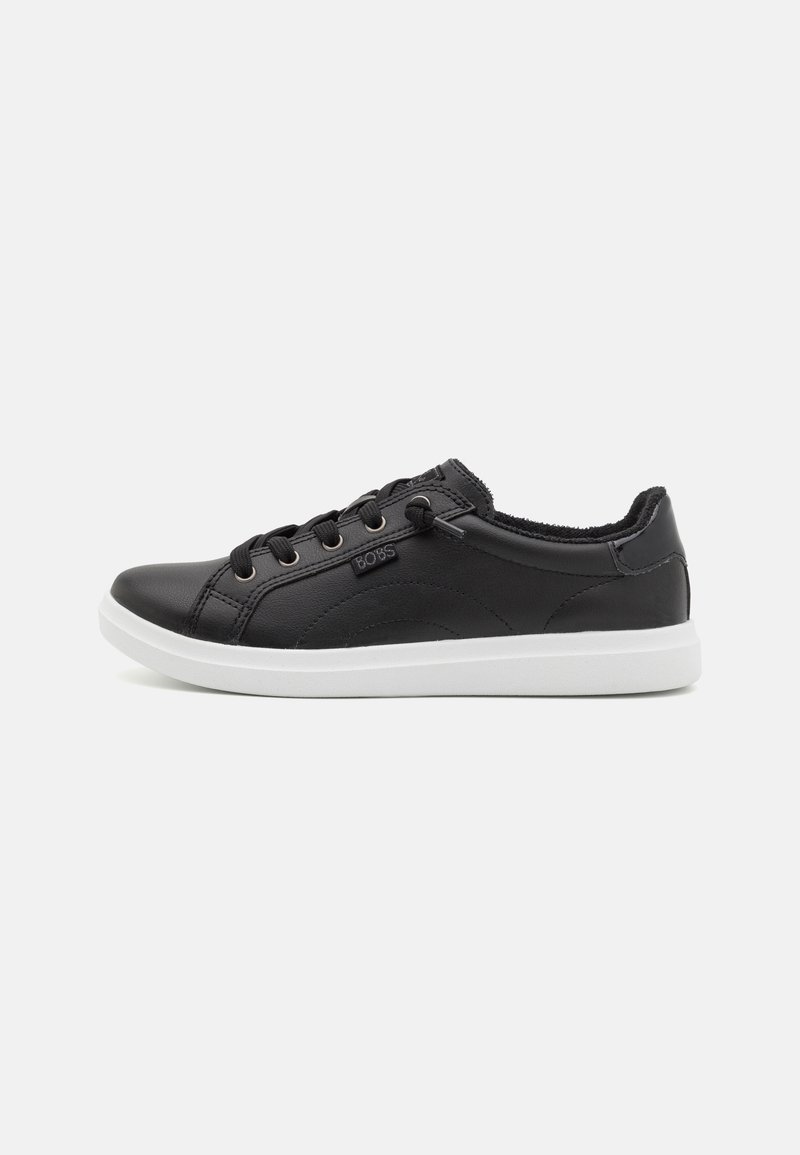 Black leather sneaker with a rounded toe, white rubber sole, and textured accents. Features laces and a logo on the side.