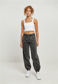 Valge lühike top, hall flanellist dressipüksid elastse vöökoha ja varrukatega, kantud valgete tossudega; sile tekstuur, mugav lõige.