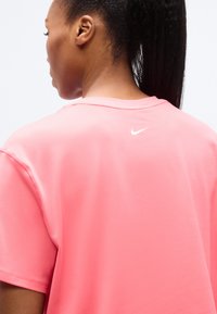 Ροζ κοντομάνικο μπλουζάκι Nike, μαλακό ύφασμα, άνετη εφαρμογή, διαθέτει λευκό λογότυπο στο επάνω μέρος της πλάτης και ριμπ λαιμόκοψη.