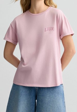 T-shirt en coton rose clair avec des manches courtes, col rond, arborant le logo "LIU JO" dans une teinte légèrement plus sombre sur la poitrine gauche.